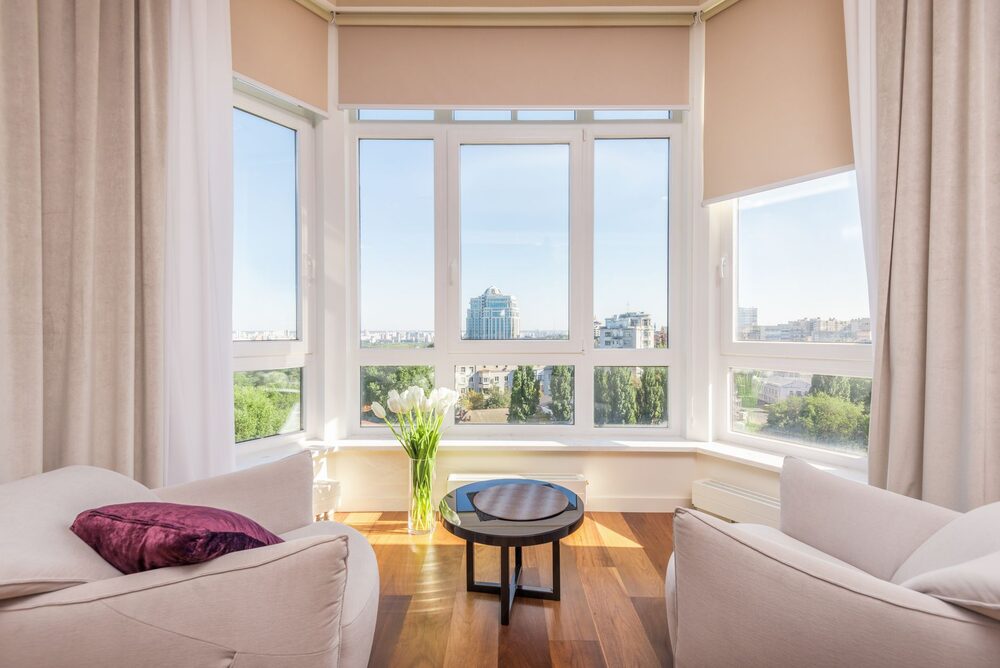 A bright apartment living room with tall windows — the kind of place people save to their PadPipe list.